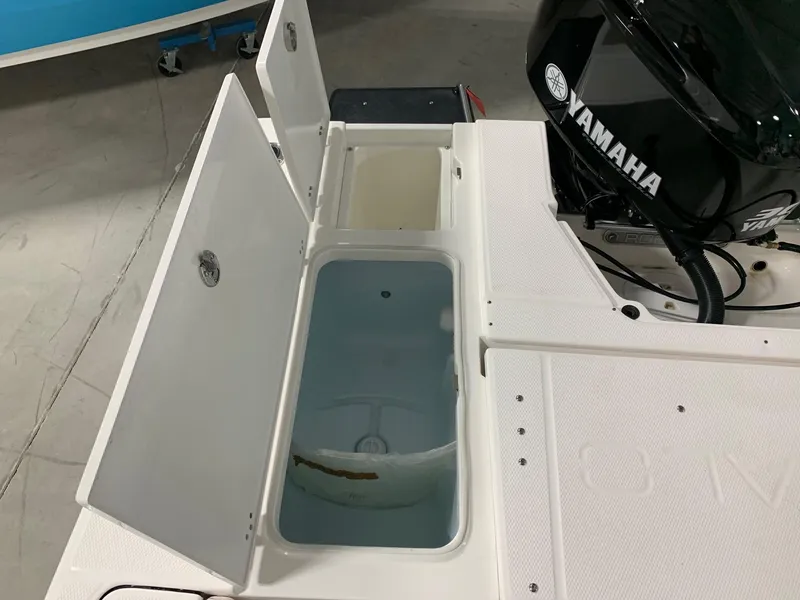 Slide: The Image of 2024 Robalo 246 Cayman boat with Yamaha engine and open storage compartments. - 16