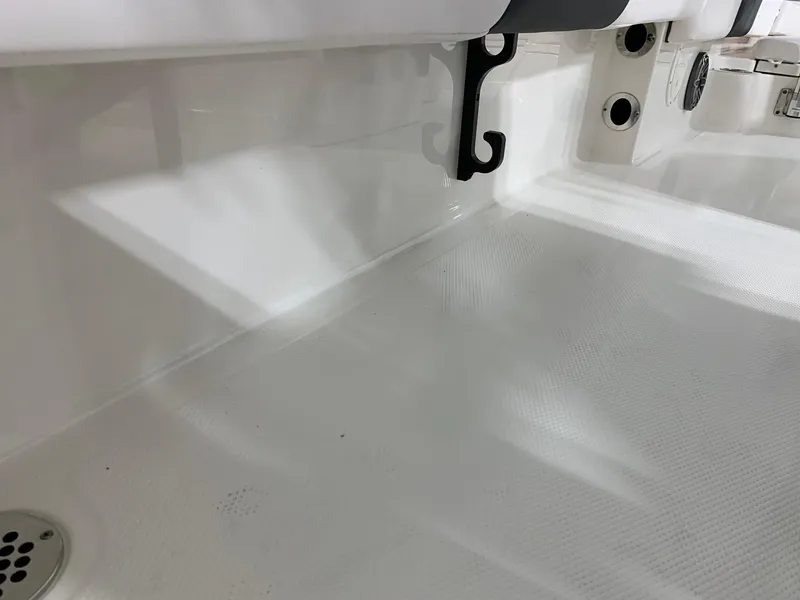 Slide: The Image of 2024 Robalo 246 Cayman boat interior, showing clean white deck and seating area. - 9