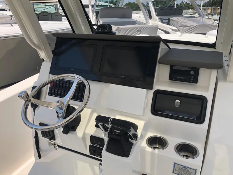 Slide: The Image of 2025 Pursuit S 288 boat dashboard with dual screens and steering wheel. - 9