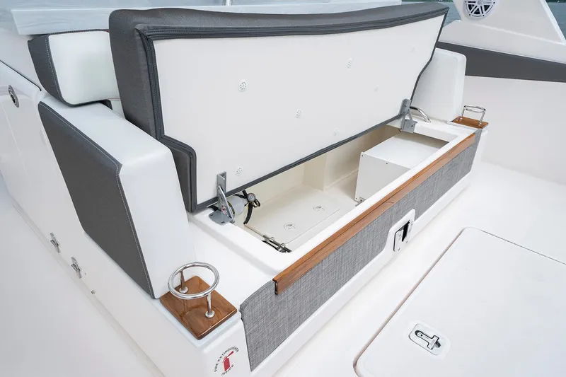 Slide: The Image of Tiara Sport 34 LS 2025 boat with open storage compartment and seating area. - 10