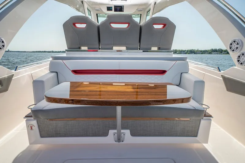 Slide: The Image of 2025 Tiara Sport 34 LS boat interior with seating and wooden table. - 12