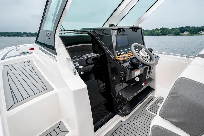 Slide: The Image of 2025 Tiara Sport 34 LS boat cockpit with modern steering console and lake view. - 14