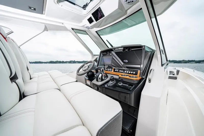 Slide: The Image of 2025 Tiara Sport 34 LS boat interior with modern dashboard and white seating. - 15