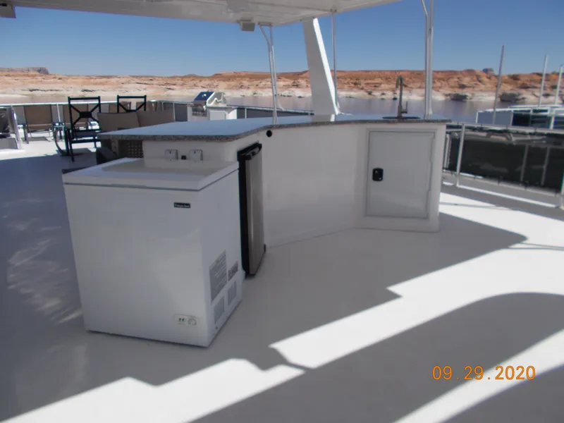 Slide: The Image of Outdoor kitchen on 2020 Sumerset Antelope Escape Share #4 houseboat, featuring appliances and seating. - 10