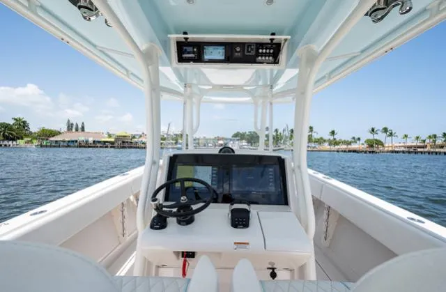 Slide: The Image of 2019 Jupiter 38 HFS boat cockpit with steering wheel, navigation screens, and waterfront view. - 4