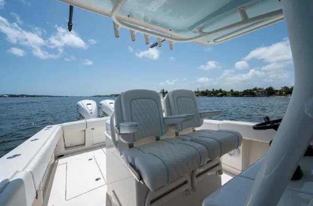 Slide: The Image of 2019 Jupiter 38 HFS boat interior with dual seats, ocean view, and clear sky. - 5
