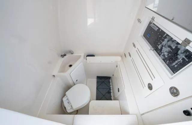 Slide: The Image of 2019 Jupiter 38 HFS boat interior with compact bathroom, featuring a toilet and sink. - 6