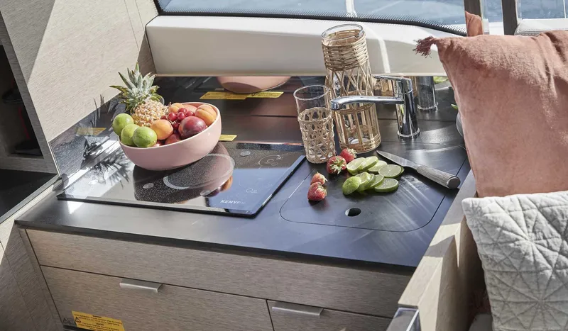 Slide: The Image of Prestige 420 2024 yacht kitchen with fruit bowl, cutting board, and modern fixtures. - 13