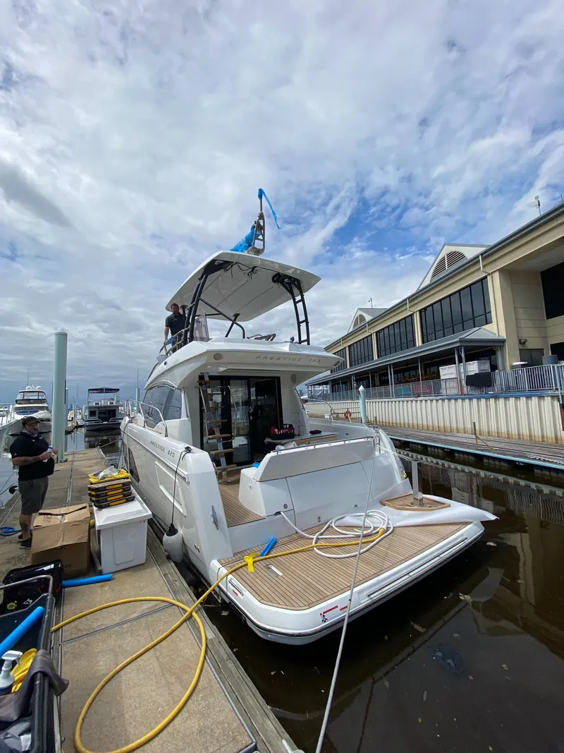 Slide: The Image of 2024 Prestige 420 yacht docked at marina with cloudy sky. - 2