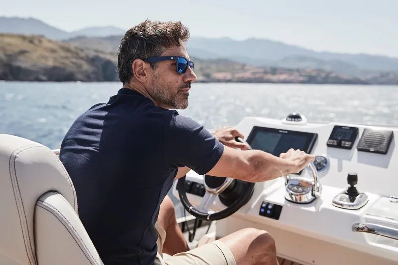 Slide: The Image of Man piloting 2024 Prestige 420 yacht on a sunny day. - 21