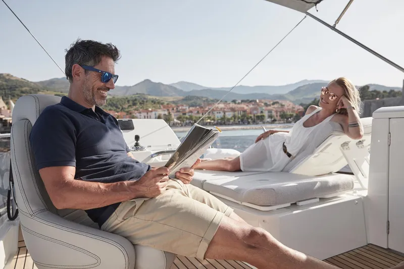 Slide: The Image of Couple relaxing on a 2024 Prestige 420 yacht, enjoying a sunny day. - 24