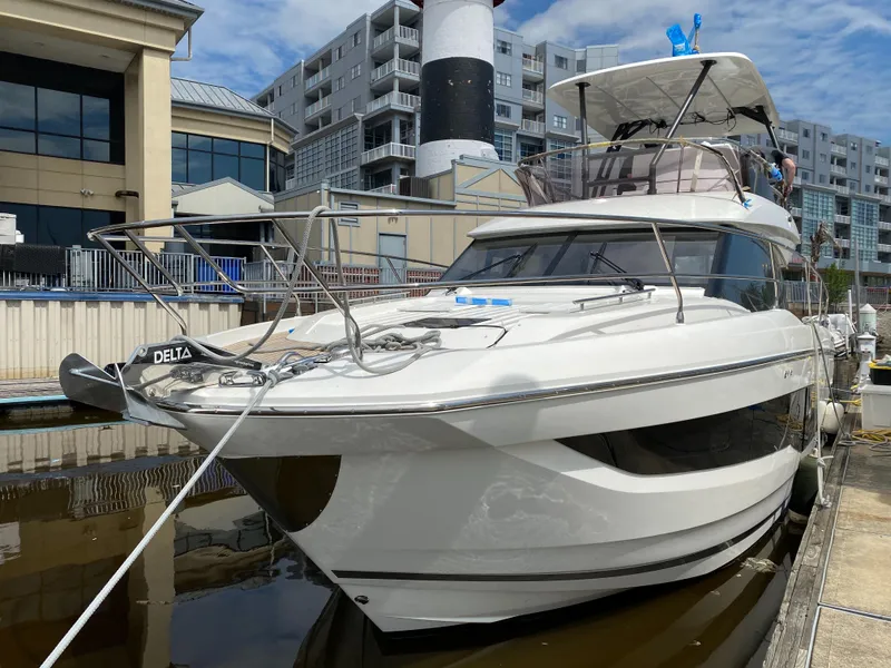 Slide: The Image of 2024 Prestige 420 yacht docked at a marina with modern buildings in the background. - 3
