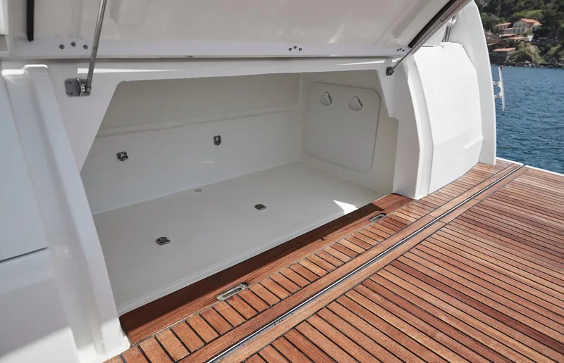Slide: The Image of Prestige 420 2024 yacht storage compartment with teak deck, open hatch, and ocean view. - 30
