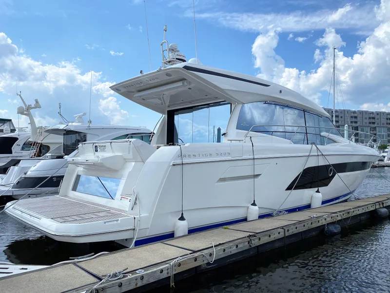 Slide: The Image of 2025 Prestige 520 S luxury yacht docked at marina under blue sky. - 0