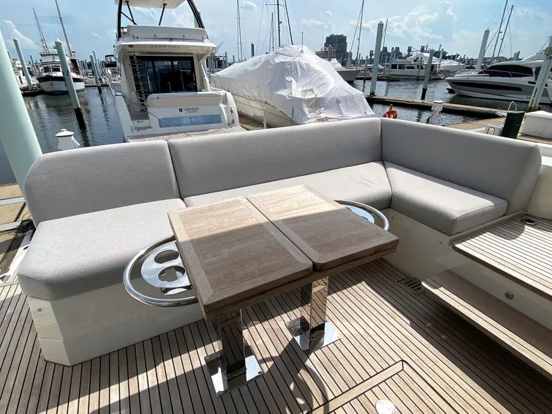 Slide: The Image of Prestige 520 S 2025 yacht with spacious outdoor seating and table at marina. - 1