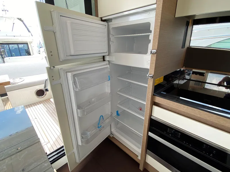 Slide: The Image of 2025 Prestige 520 S yacht kitchen with open refrigerator and modern appliances. - 11