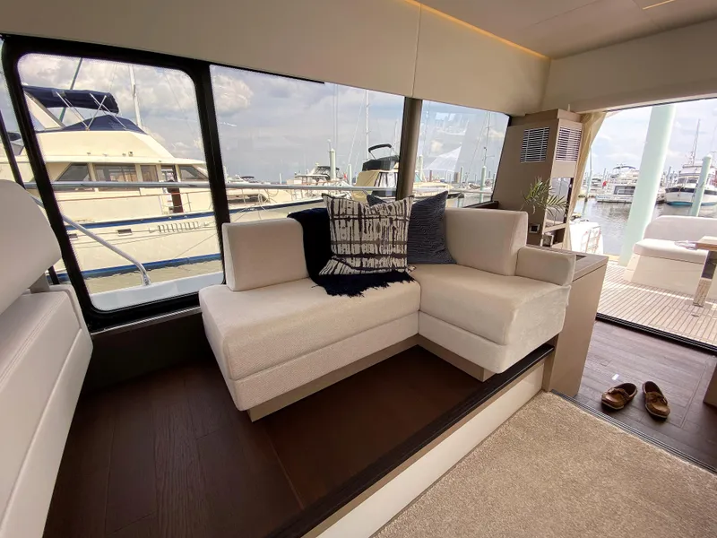 Slide: The Image of Interior of 2025 Prestige 520 S yacht with modern seating and marina view. - 13