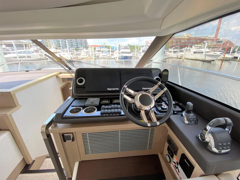 Slide: The Image of Interior helm of 2025 Prestige 520 S yacht with modern controls and marina view. - 15
