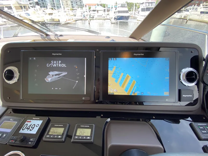 Slide: The Image of Prestige 520 S 2025 yacht dashboard with navigation and control screens at marina. - 18