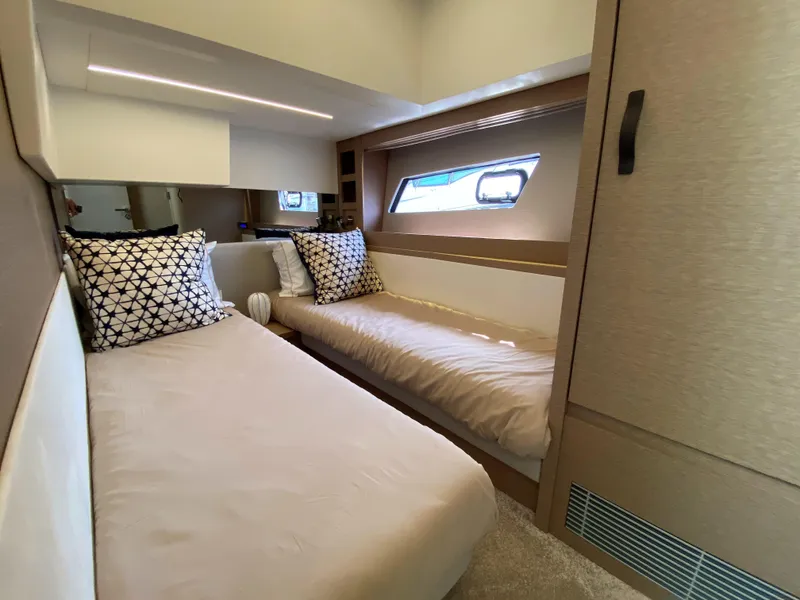Slide: The Image of Prestige 520 S 2025 model yacht cabin with twin beds and modern decor. - 26
