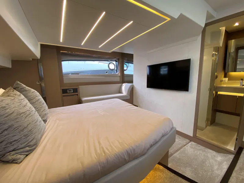Slide: The Image of Prestige 520 S 2025 yacht bedroom with modern design, large bed, TV, and ensuite bathroom. - 29