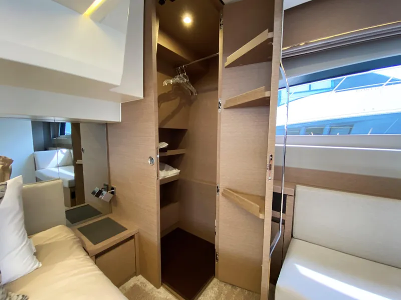 Slide: The Image of Prestige 520 S 2025 yacht interior with open closet and seating area. - 33