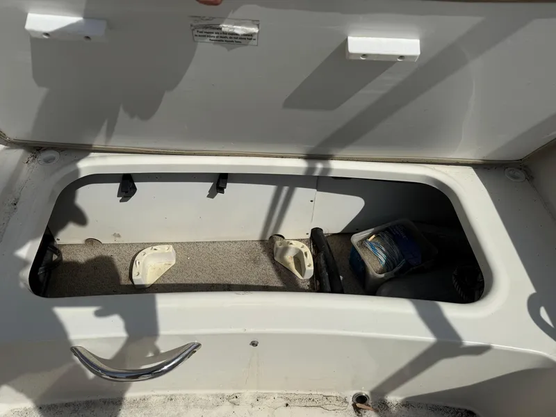 Slide: The Image of Open storage compartment in a 2018 Stingray 191 boat, showing interior space and items. - 13