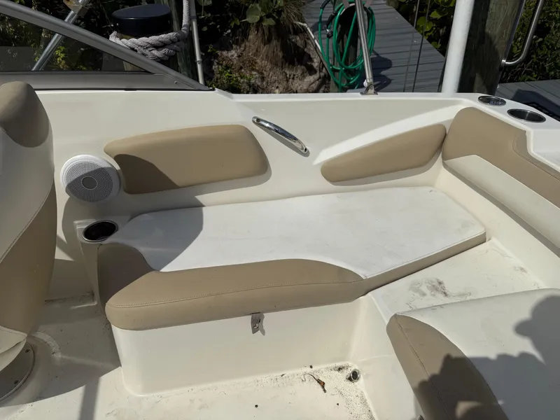 Slide: The Image of Interior seating of a 2018 Stingray 191 boat, featuring beige and white upholstery. - 14