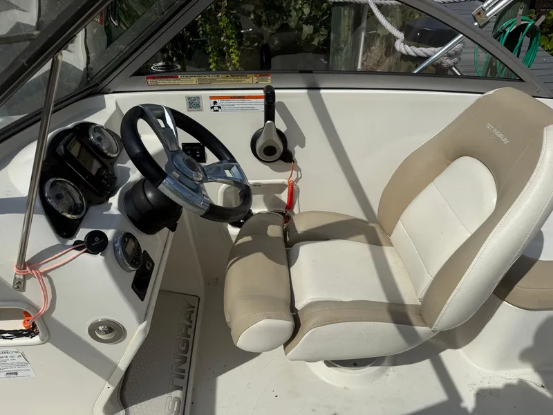 Slide: The Image of 2018 Stingray 191 boat interior with steering wheel and beige seating. - 19