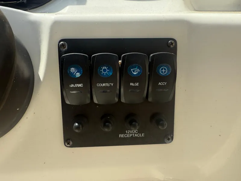 Slide: The Image of Control panel of a 2018 Stingray 191 boat with labeled switches and 12VDC receptacle. - 22