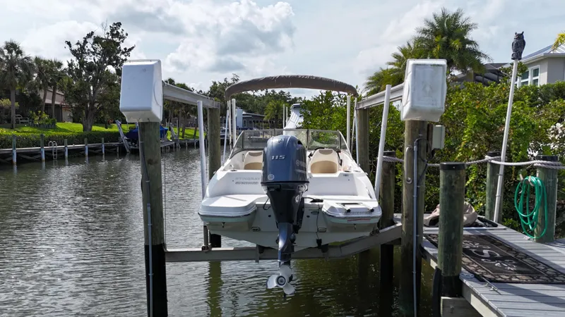 Slide: The Image of 2018 Stingray 191 boat docked on a lift in a scenic canal setting. - 3