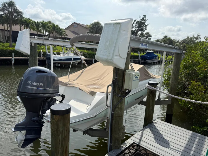 Slide: The Image of 2018 Stingray 191 boat with Yamaha motor docked in a scenic marina. - 6