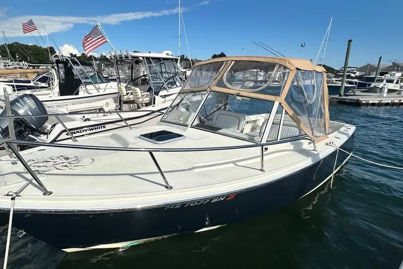 Slide: The Image of 2004 Medeiros Limestone 24 Cuddy Cabin boat docked in marina, clear canopy, sunny day. - 28