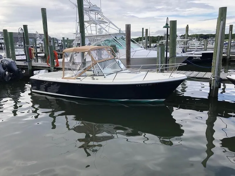 Slide: The Image of 2004 Medeiros Limestone 24 Cuddy Cabin boat docked at a marina. - 3