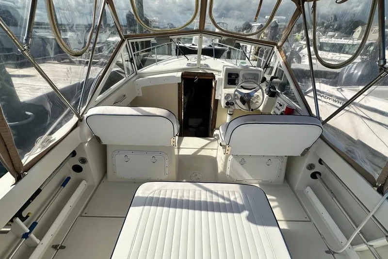 Slide: The Image of 2004 Medeiros Limestone 24 Cuddy Cabin interior with helm and seating area. - 31