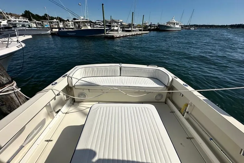 Slide: The Image of 2004 Medeiros Limestone 24 Cuddy Cabin boat docked in a marina, featuring spacious seating. - 32