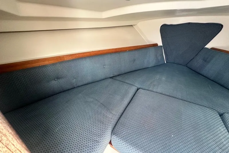 Slide: The Image of 2004 Medeiros Limestone 24 Cuddy Cabin interior with blue cushioned seating. - 36