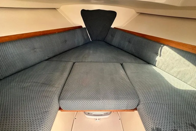 Slide: The Image of 2004 Medeiros Limestone 24 Cuddy Cabin interior with cushioned seating and wood accents. - 37