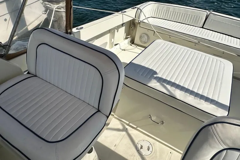 Slide: The Image of 2004 Medeiros Limestone 24 Cuddy Cabin with white cushioned seating and nautical design. - 38