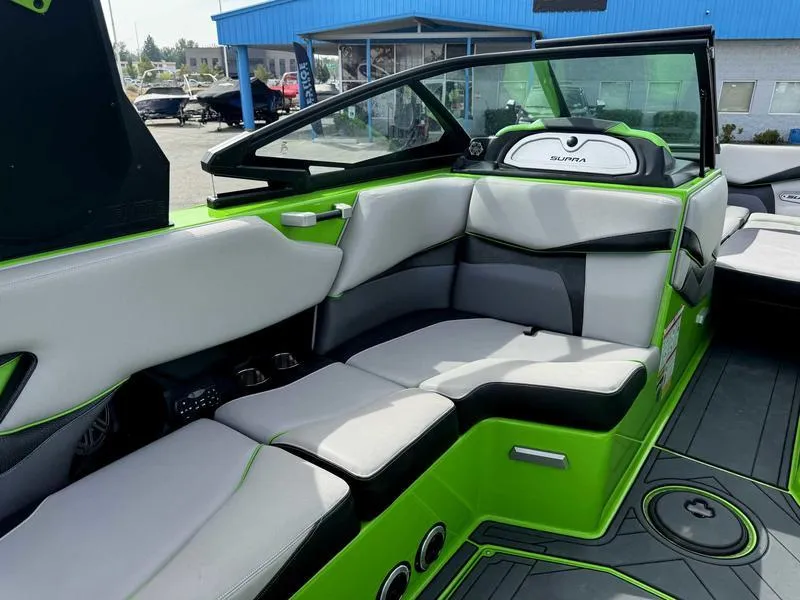 Slide: The Image of 2018 Supra SA450 boat interior with green and gray seating, modern design, and spacious layout. - 14