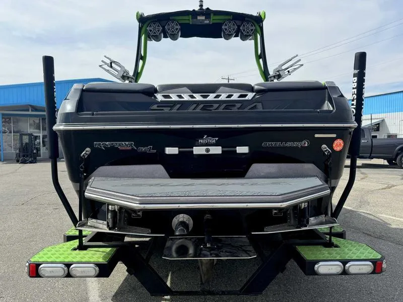 Slide: The Image of 2018 Supra SA450 boat, rear view, black and green design, parked outdoors. - 3