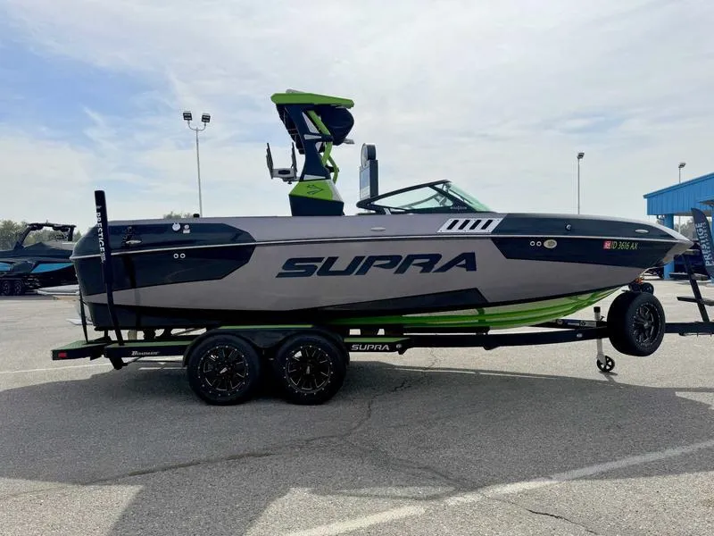 Slide: The Image of 2018 Supra SA450 boat on trailer, gray and green design, parked outdoors. - 5