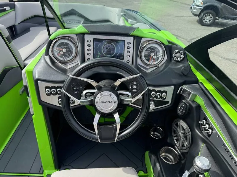 Slide: The Image of Cockpit of 2018 Supra SA450 boat with green accents and advanced controls. - 7