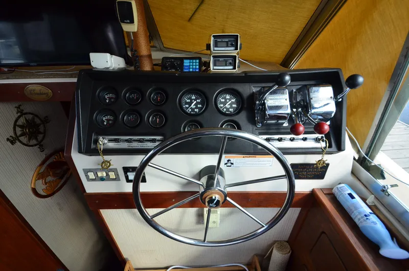 Slide: The Image of 1975 Bayliner Montego boat helm with steering wheel and control panel. - 12
