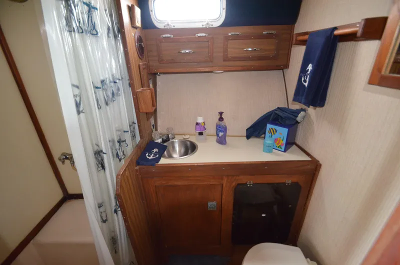 Slide: The Image of 1975 Bayliner Montego boat bathroom with sink, storage cabinets, and shower. - 17