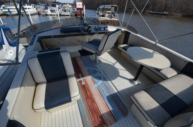 Slide: The Image of 1975 Bayliner Montego boat interior with seating and table, docked at a marina. - 18