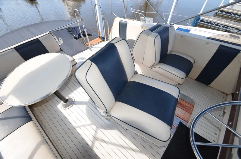 Slide: The Image of 1975 Bayliner Montego boat interior with white and navy seating, round table, and deck view. - 20