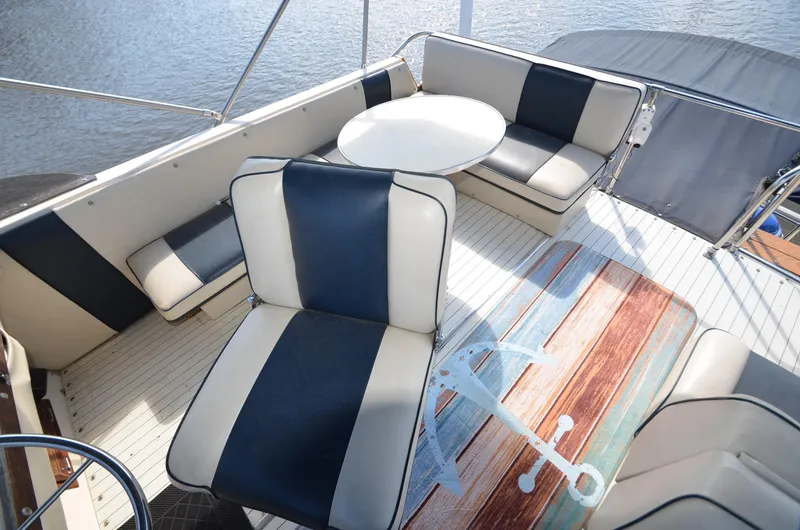 Slide: The Image of 1975 Bayliner Montego boat interior with cushioned seating and table. - 21