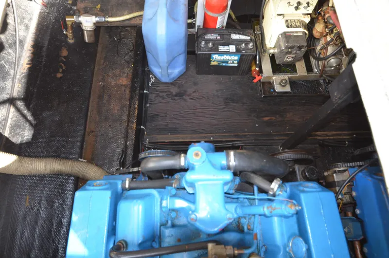 Slide: The Image of 1975 Bayliner Montego engine compartment with blue engine, battery, and fuel container. - 24