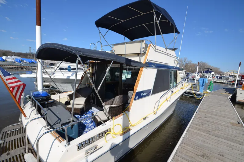 Slide: The Image of 1975 Bayliner Montego boat docked at marina with American flag. - 3